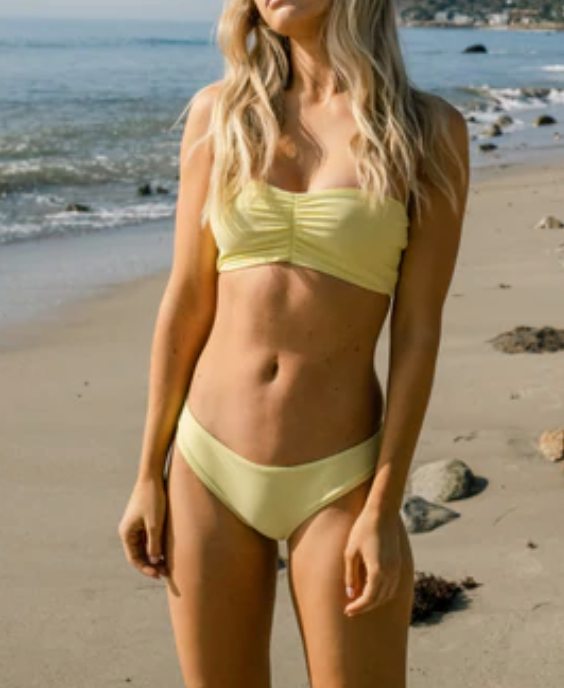 Model standing on beach wearing the Ava Bandeau and Lure Bottom in Sand