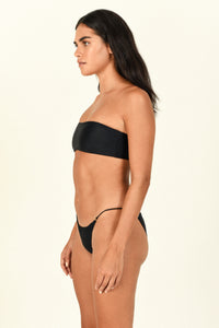Model standing to the side showing the side of the All Around Bandeau in black