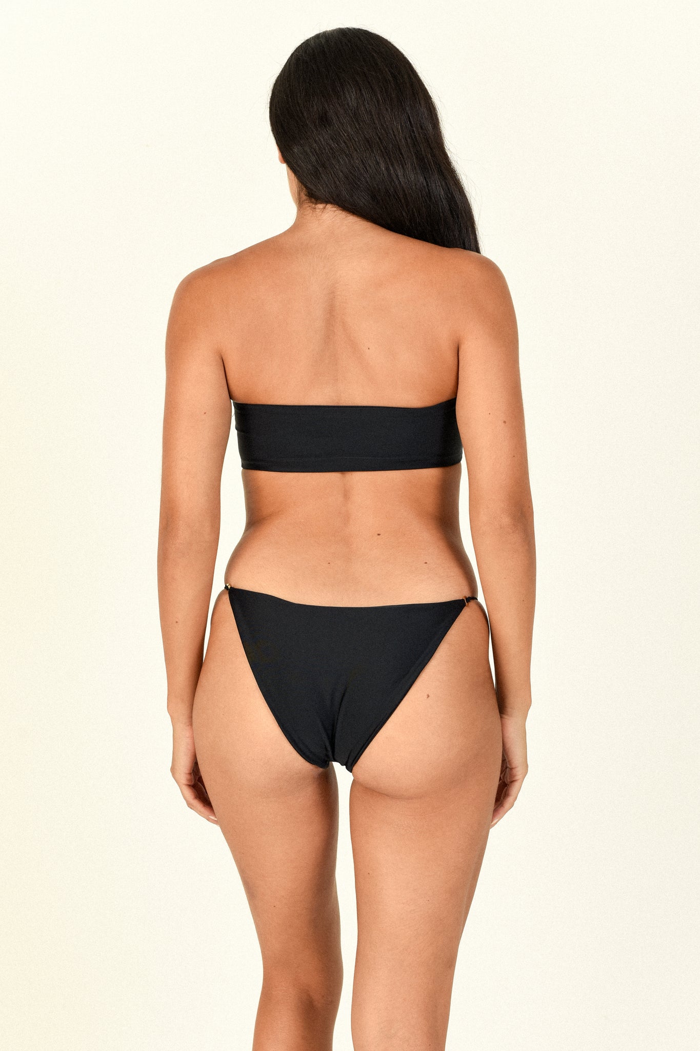 Load image into Gallery viewer, Model standing backwards showing the back of the All Around Bandeau in black