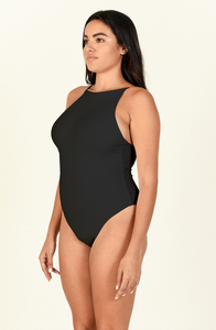Model standing to the side  wearing the Nova One Piece in Black
