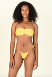 Model standing against white background wearing the Ava Bandeau and Lana Bottom in Sand