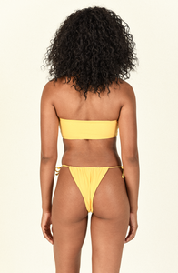 Model standing in front of white background showing the back of the Ava Bandeau and Lana Bottom in Blonde