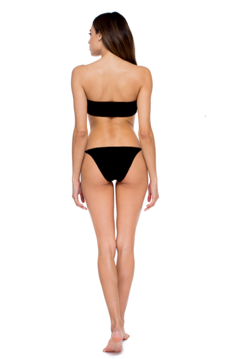 Load image into Gallery viewer, Model posing against white background while showing the back of the All Around Bandeau and Bare Minimum Bottom in Black