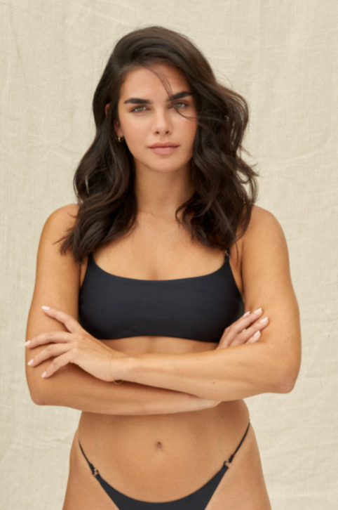 Load image into Gallery viewer, Model standing with arms crossed while wearing the Hinge Top in Black paired with the Aria Bottoms