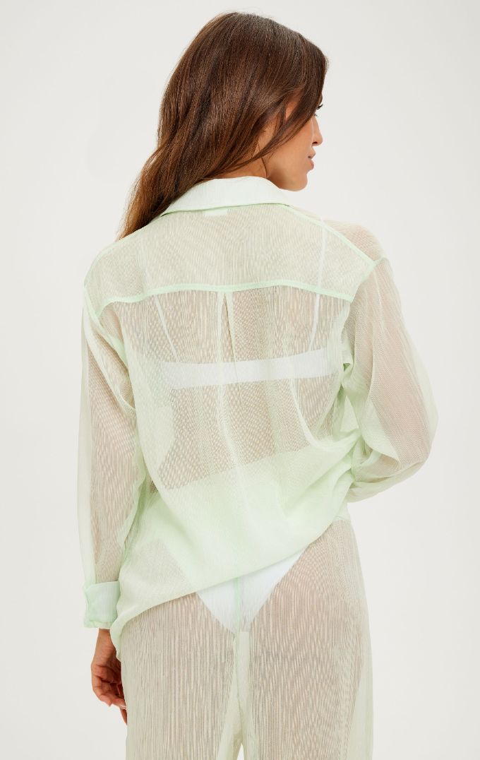 Load image into Gallery viewer, Model standing against a wall showing the back of the Mika Top and Mika Pant in Aloe