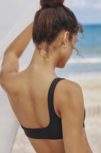 Model standing on beach showing the back of the Avery Top in black